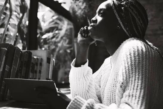 Writer sitting beside a stack of books